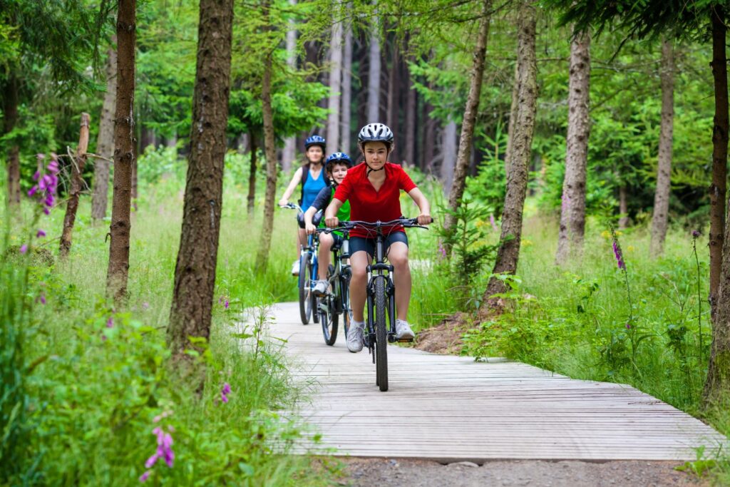 Family biking along wooded trail