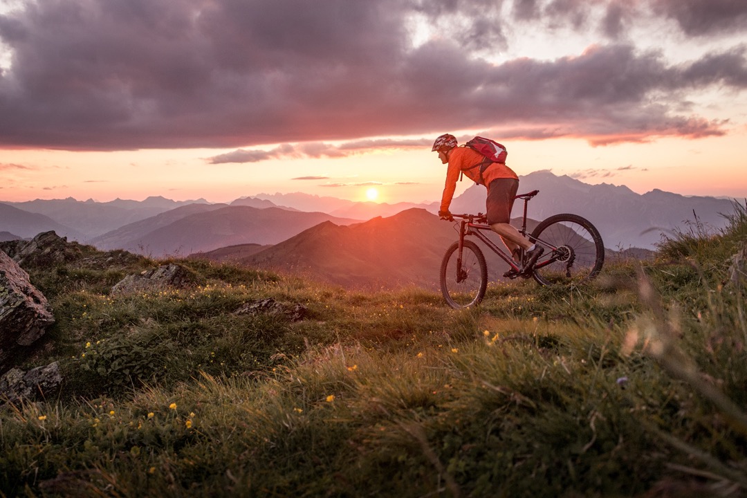 Man mountain biking in the mountains at sunset